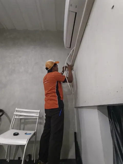 Teknisi merapikan jalur kabel CCTV di dinding