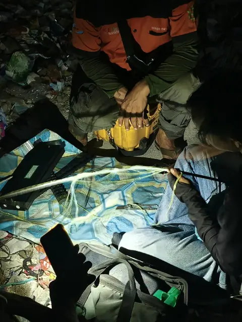Teknisi menyambung core kabel fiber saat perbaikan jaringan malam hari